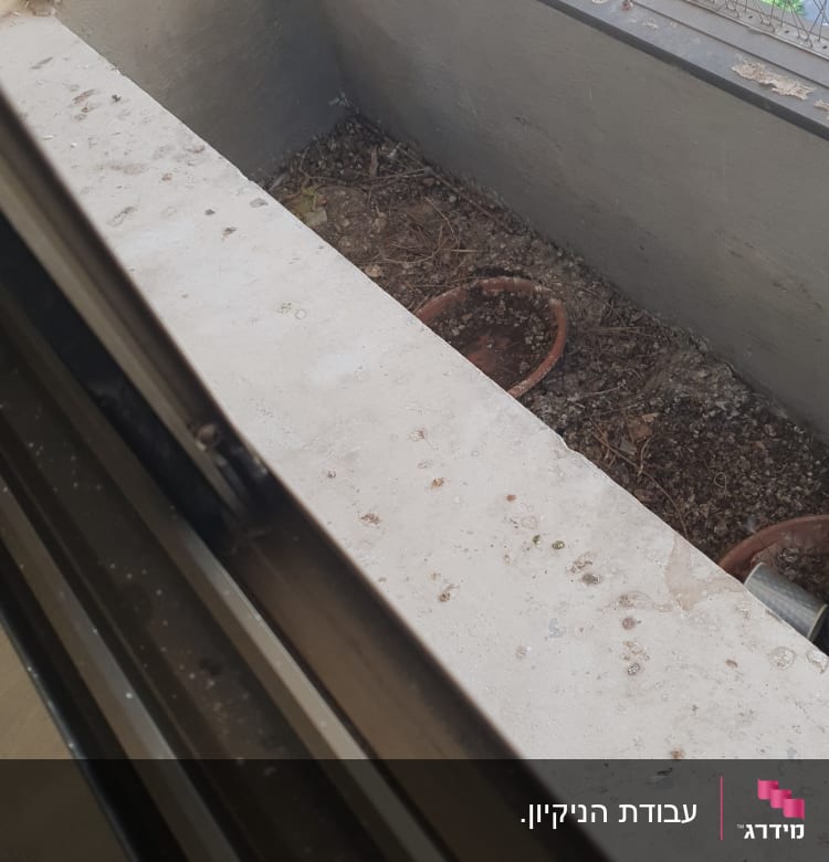 אדנית מלוכלכת עם אדמה וענפים יבשים